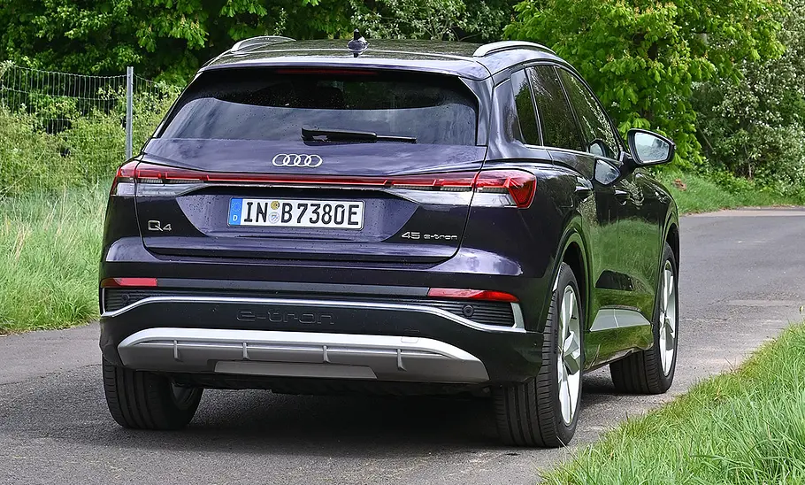 Audi Q4 45 e-tron Audi Q4 45 e-tron im Grünen fahrend von hinten.