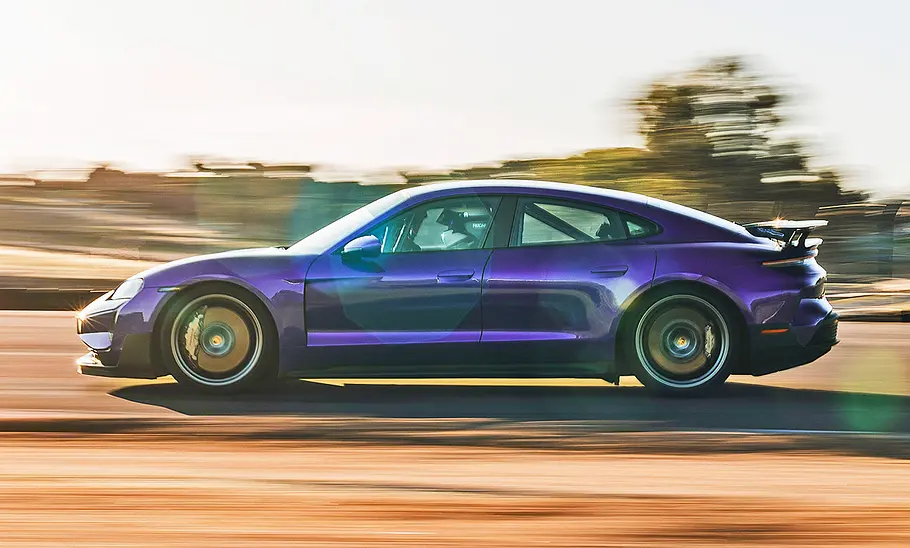 Porsche Taycan Turbo GT (2024) mit Weissach-Paket Der Porsche Taycan Turbo GT (2024) mit Weissach-Paket fährt über eine Rennstrecke, von der Seite fotografiert.