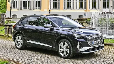 Audi Q4 45 e-tron parkt auf Kopfsteinpflaster, Ansicht von vorne rechts. - Foto: Nils Koshofer