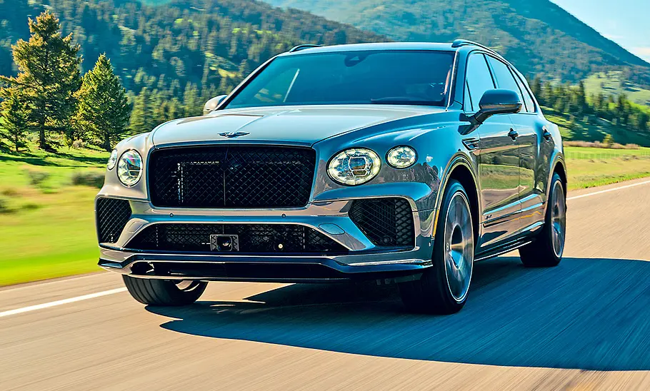 Bentley Bentayga Speed (2025) Bentley Bentayga Speed (2025) fährt auf einer Landstraße, Ansicht von vorne links.