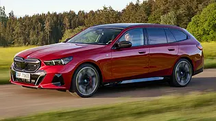 BMW i5 Touring (2024) in rot, fahrend, Ansicht von links vorne - Foto: BMW