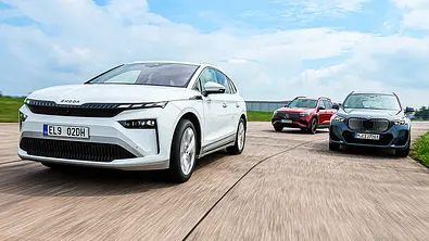 Gruppenbild mit Blick von vorne auf die fahrenden E-SUV Skoda Enyaq, Mercedes EQB und BMW iX1. - Foto: Daniela Loof