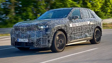 Der BMW iX5 Hydrogen (2028) fährt als Erlkönig auf einer Straße, von vorne links fotografiert. - Foto: BMW