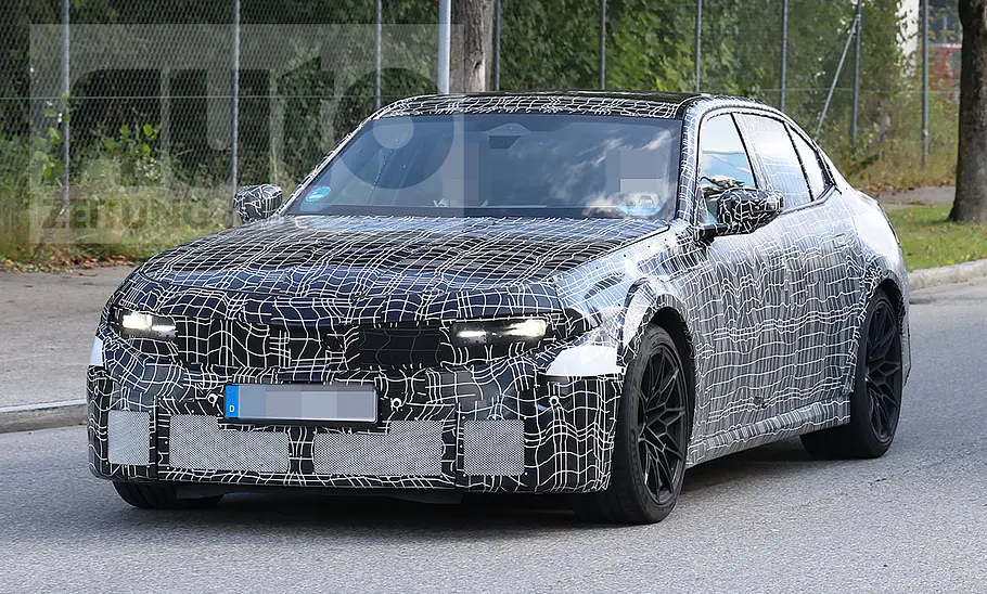 Der BMW M3 (2027) fährt als Erlkönig auf einer Straße, von vorne fotografiert.