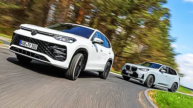 Blick von schräg vorne auf die beiden fahrenden SUV VW Tayron und BMW X3. - Foto: Daniela Loof