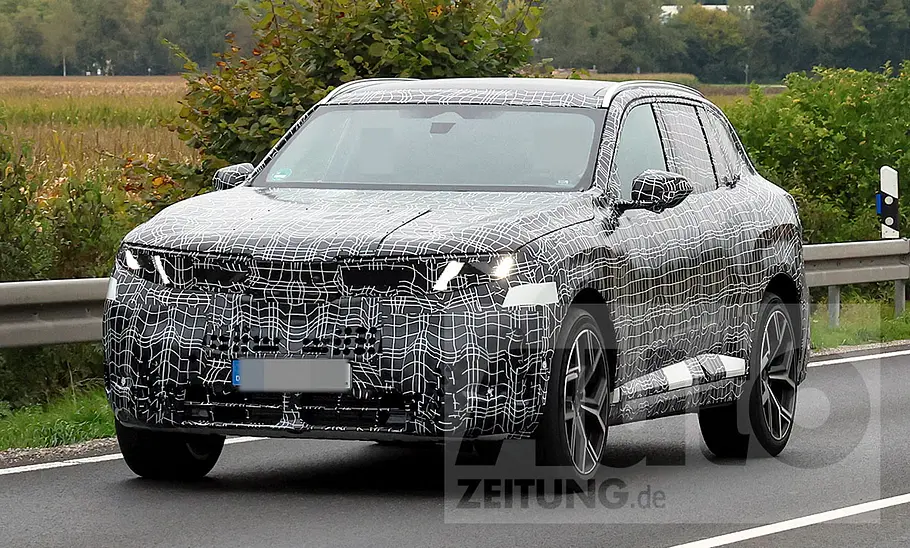 BMW X5 (2025) Der BMW X5 (2025) fährt als Erlkönig auf einer Landstraße, von vorne links fotografiert.