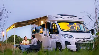 Camping im Wohnmobil Außenansicht: Abendstimmung vor dem Camper - Foto: Hobby