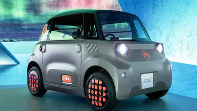 Der Citroën Ami Facelift (2025) steht in Studioumgebung, von vorne rechts fotografiert. - Foto: Citroën