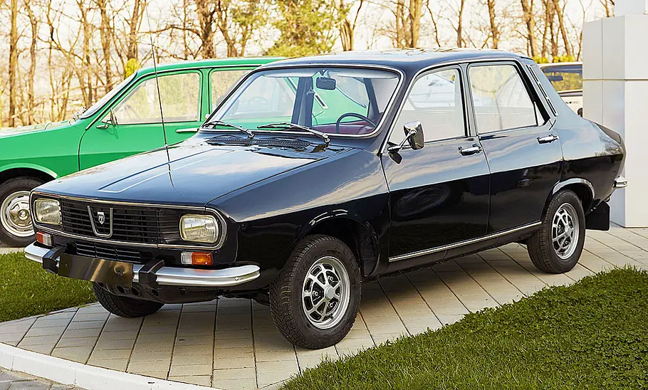 Der Dacia 1300 stehend von der Seite, im Hintergrund sieht man ein anderes Fahrzeug.