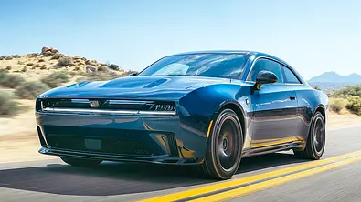 Der Dodge Charger Daytona (2025) fährt eine US-amerikanische Landstraße entlang, von vorne links fotografiert. - Foto: Olgun Kordal