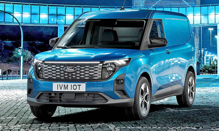 Der Ford E-Transit Courier (2025) steht in urbaner Umgebung, von vorne links fotografiert.