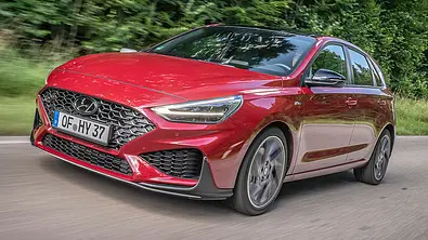 Der Hyundai i30 (2021) fährt über eine Straße im Grünen, von vorne links fotografiert. - Foto: Hyundai