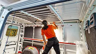 Eine Person steht in einem leeren Transporter, die Wände haben keine Verkleidung, man erkennt Isolierplatten in den Karosseriefeldern im Innenraum. - Foto: Imago