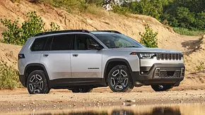 Der Jeep Cherokee steht in hügeligem Gelände, von vorne rechts fotografiert. - Foto: Jeep