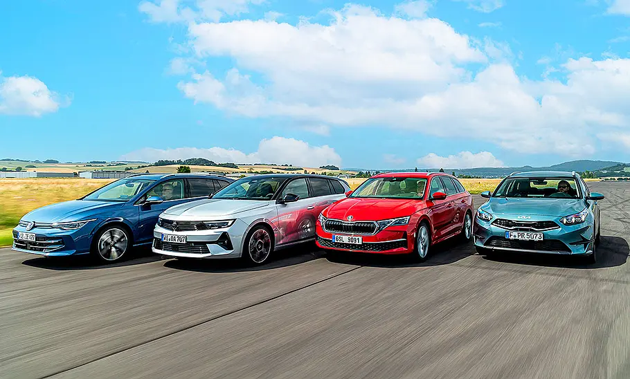 Gruppenbild mit Blick von vorne auf die fahrenden Kompakt-Kombis VW Golf Variant, Opel Astra Sports Toure, /Skoda Octavia Combi und Kia Ceed Sportswagon.