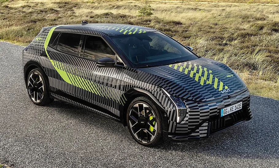 Der Kia EV4 GT (2026) steht auf einem asphaltierten Weg, von vorne rechts fotografiert.