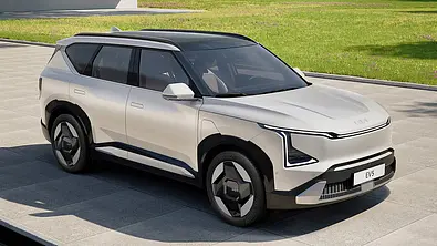 Der Kia EV5 (2025) steht in einer Einfahrt, von vorne rechts fotografiert. - Foto: Kia