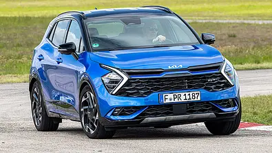 Der Kia Sportage (2021) fährt durch eine Linkskurve, von vorne rechts fotografiert. - Foto: Frank Ratering