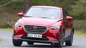 Der Mazda CX-3 (2018) fährt eine Rechtskurve, von vorne fotografiert. - Foto: Daniela Loof