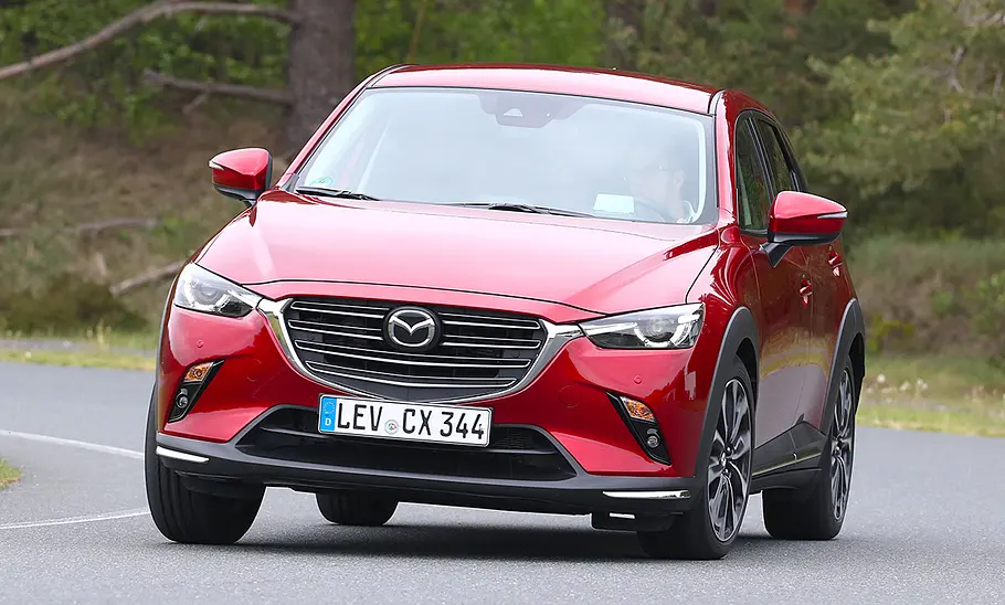 Mazda CX-3 (2018) Der Mazda CX-3 (2018) fährt eine Rechtskurve, von vorne fotografiert.
