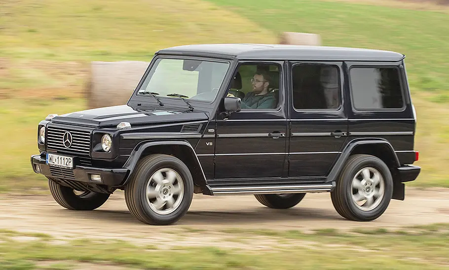 Mercedes G-Klasse (W463) Die Mercedes G-Klasse (W463) fährt einen Feldweg entlang, von vorne links fotografiert.