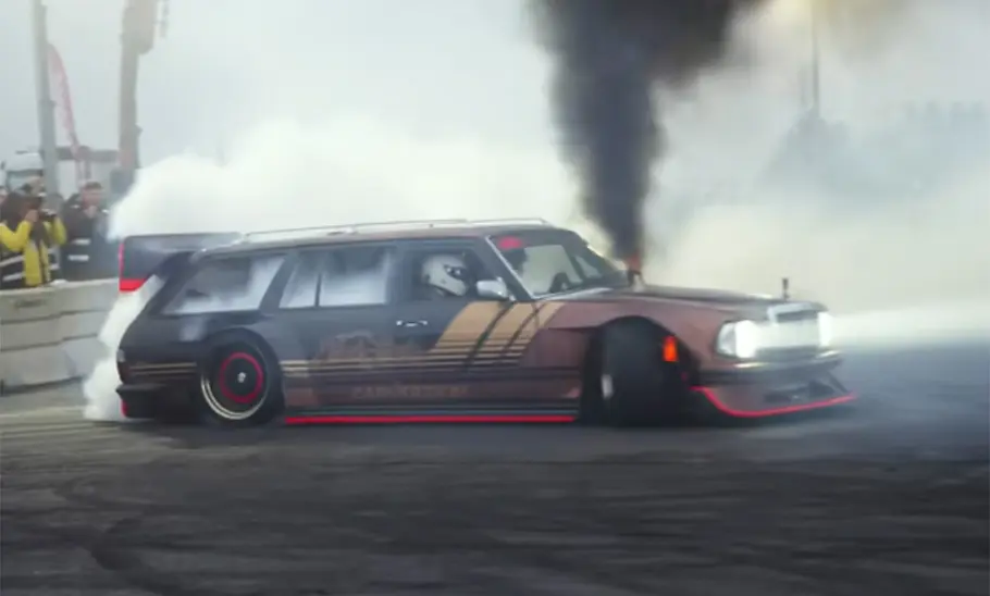 Getunter Mercedes S123 beim Driften mit Rauchwolken, fotografiert von der Seite.