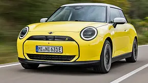 Mini Cooper SE (2024) in gelb, fahrend, von vorne rechts - Foto: Mini
