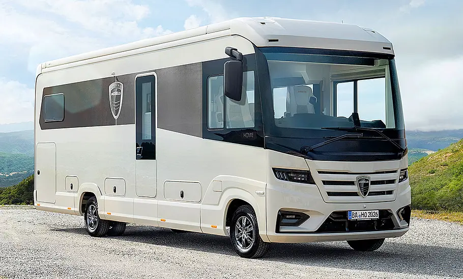 Der Morelo Home (2025) statisch von schräg vorne rechts fotografiert. Der Camper steht auf einem Schotterplatz vor einer Bergkulisse.