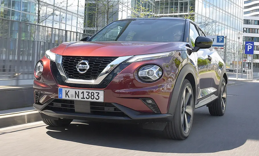 Der Nissan Juke (2019) fährt durch eine urbane Umgebung, von vorne fotografiert.