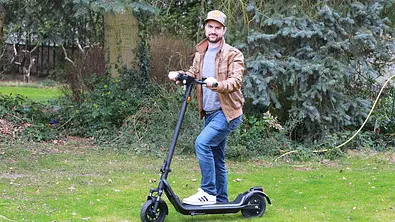 Niu KQi 100E mit Tester im Stand im Garten fotografiert. - Foto: Holger Ippen