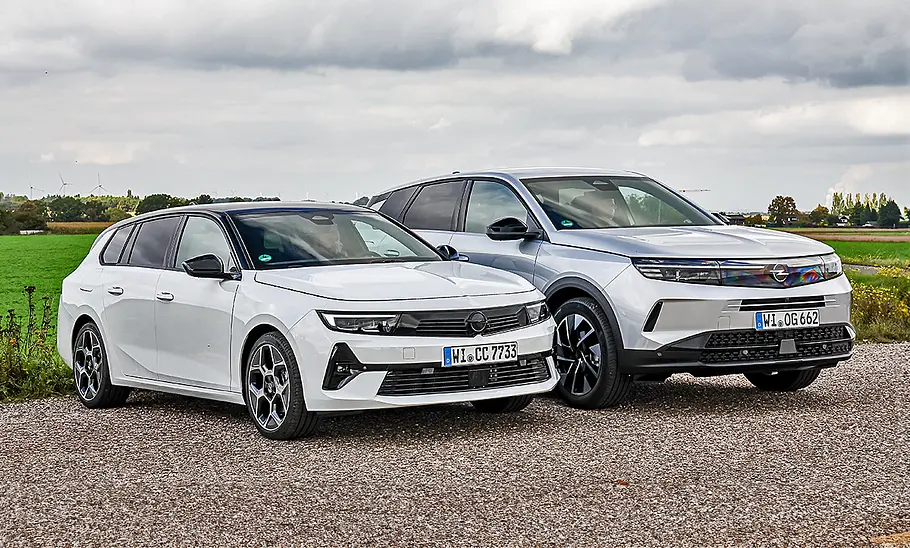 Blick von schräg vorne auf den Opel Astra Sports Tourer und Opel Grandland, die nebeneinander stehen.