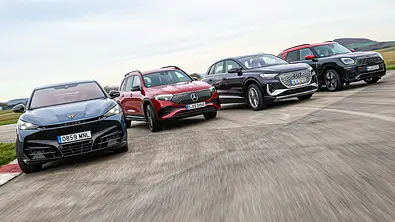 Cupra Tavascan VZ, Mercedes EQB, Audi Q4 e-tron und Mini Countryman SE fahren nebeneinander durch eine Rechtskurve, von vorne fotografiert. - Foto: Daniela Loof