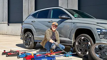 Tester mit sechs Rangierwagenhebern, Auto und Reifenstapel, fotografiert von der Seite. - Foto: Wim Woeber
