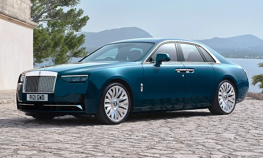 Rolls-Royce Ghost Facelift (2025) Das Rolls-Royce Ghost Facelift (2025) steht vor einer Villa, von vorne links fotografiert.