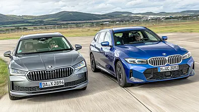 Skoda Superb Combi und BMW 3er Touring fahren über eine Flugzeuglandebahn, von vorne fotografiert. - Foto: Frank Ratering