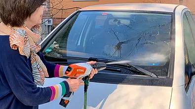 Person beim Absprühen einer Windschutzscheibe mit Stihl Akku-Druckreiniger RCA 20. - Foto: Holger Ippen