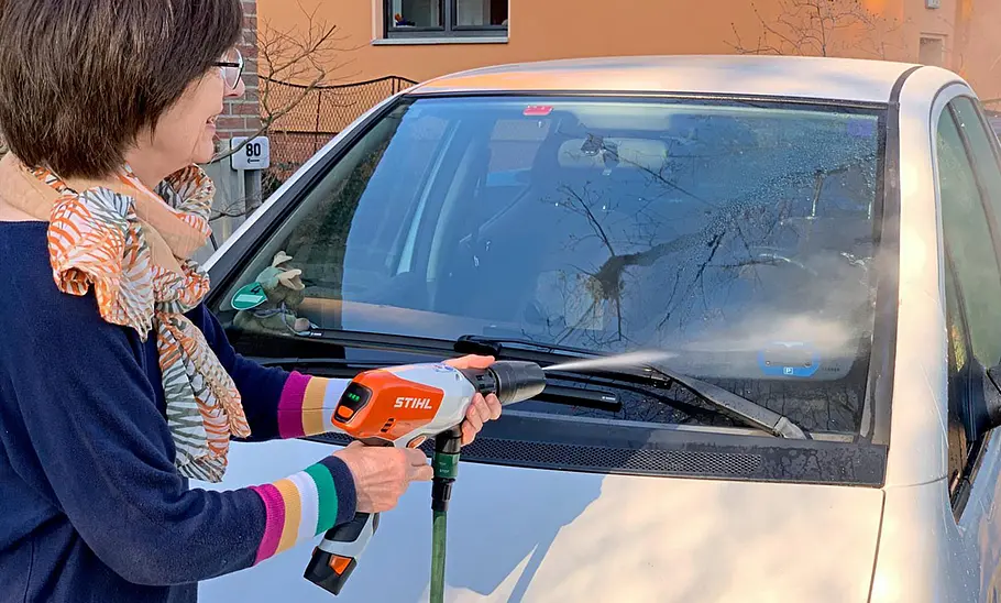 Stihl Akku-Druckreiniger RCA 20 im Test Person beim Absprühen einer Windschutzscheibe mit Stihl Akku-Druckreiniger RCA 20.