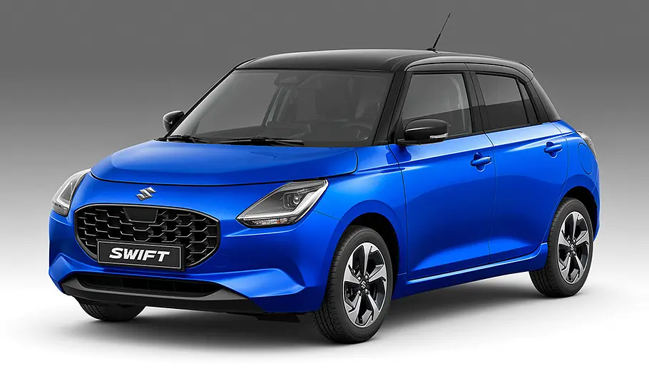 Suzuki Swift steht vor grauem Hintergrund, Ansicht von vorne links.