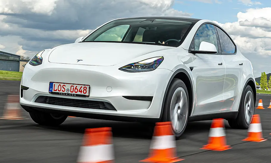 Weises Tesla Model Y Maximale Reichweite RWD fahrend, von schräg vorne