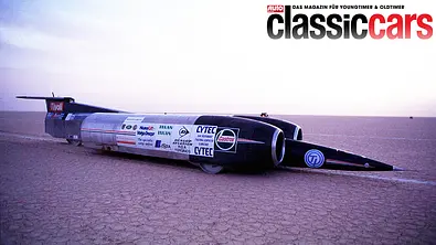 Das Hochgeschwindigkeitsauto ThrustSSC steht in einer Wüste, von vorne rechts fotografiert. - Foto: Imago