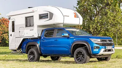 Die Außenaufnahme zeigt die Wohnkabine Tischer Trail 230 S (2025) auf einem VW Amarok statisch von schräg vorne rechts. - Foto: VW Nutzfahrzeuge