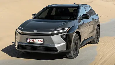 Das Toyota bZ4X Facelift fährt auf einer sandverwehten Straße, von vorne links fotografiert. - Foto: Toyota