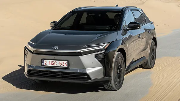 Das Toyota bZ4X Facelift fährt auf einer sandverwehten Straße, von vorne links fotografiert. - Foto: Toyota