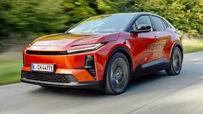 Der Toyota C-HR+ (2025) fährt auf einer Landstraße, von vorne links fotografiert. - Foto: Toyota