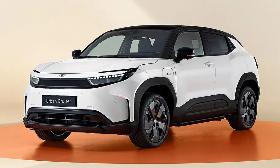 Toyota Urban Cruiser (2025) Toyota Urban Cruiser (2025) im Studio vor beigem Hintergrund, Ansicht von vorne links.