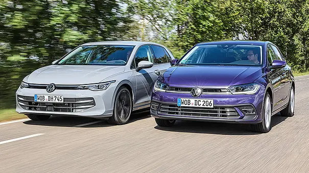VW Golf und VW Polo fahren nebeneinander auf einer Landstraße, von vorne fotografiert. - Foto: Daniela Loof