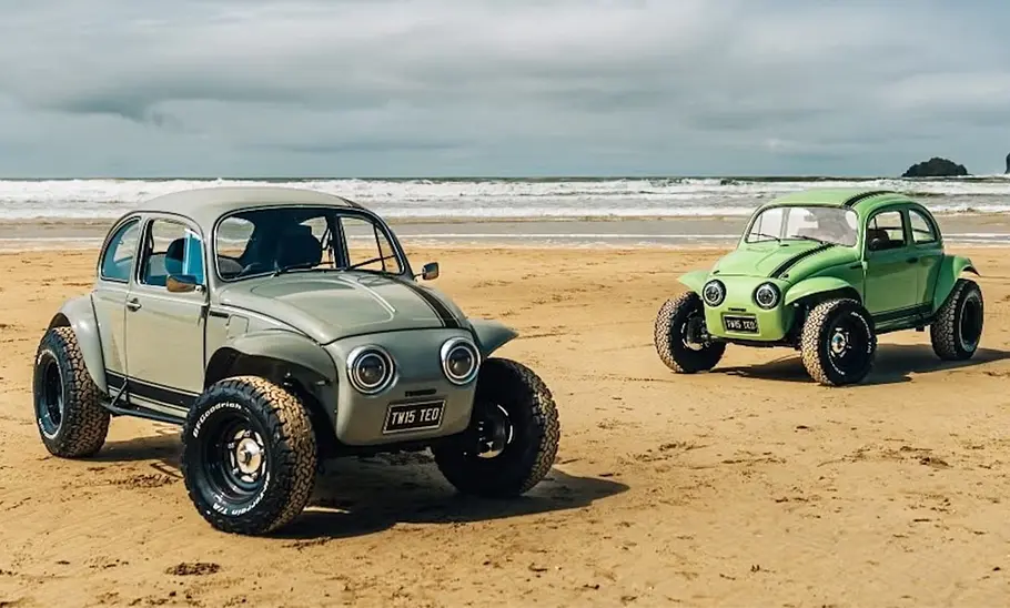 Zwei VW Twisted Tbug am Strand, fotografiert von schräg vorne.