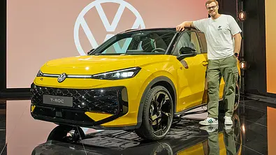 Blick von schräg vorne auf den VW T-Roc. Jemand steht vor dem Auto. - Foto: Volkswagen