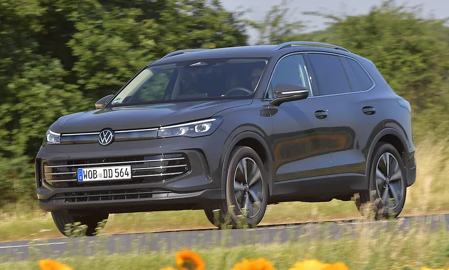 VW Tiguan Der VW Tiguan fährt auf einer Landstraße, Ansicht von vorne links.