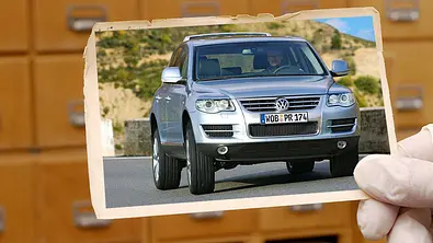 VW Touareg V8 (2007); Person hält Foto von Auto in der Hand - Foto: AUTO ZEITUNG